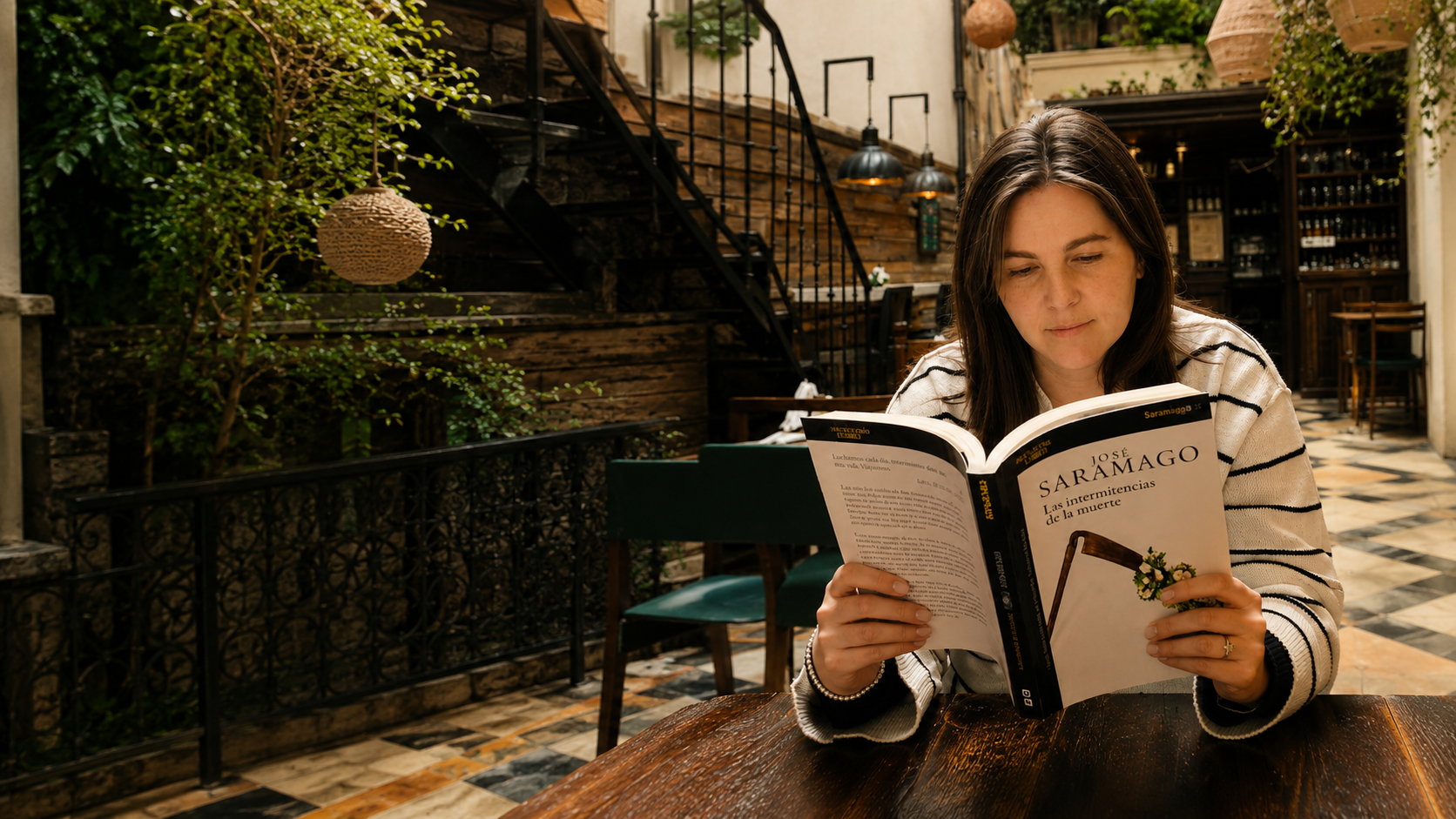 Eli Tarasiuk leyendo en un patio de librería, rodeada de libros y plantas.
